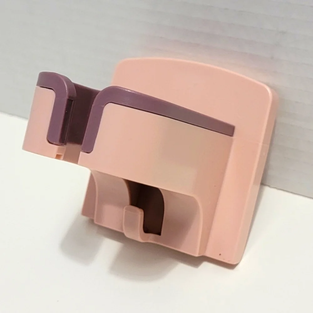 Pink and Purple Wall-Mounted Blow Dryer Holder.